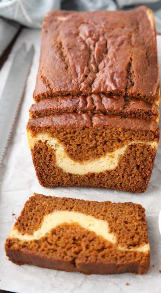 Sliced pumpkin loaf with cream cheese ribbon.